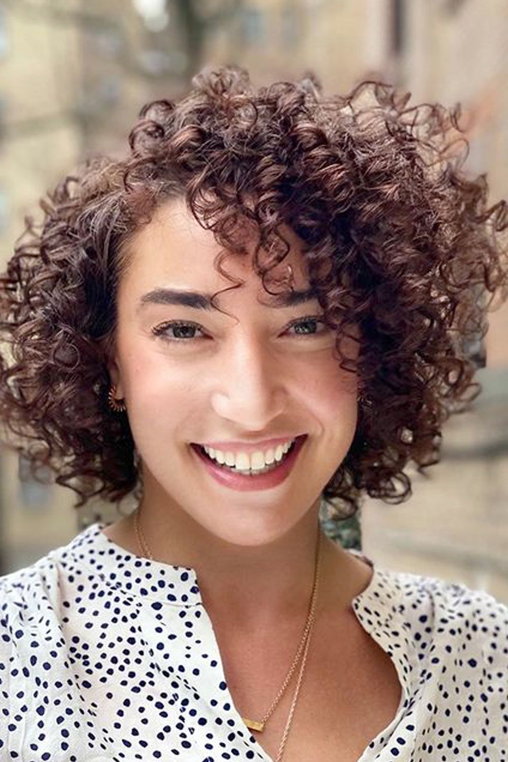 Short side parted curly hair appears playful and vivid, while you can only flip your curls to the side to achieve the style.