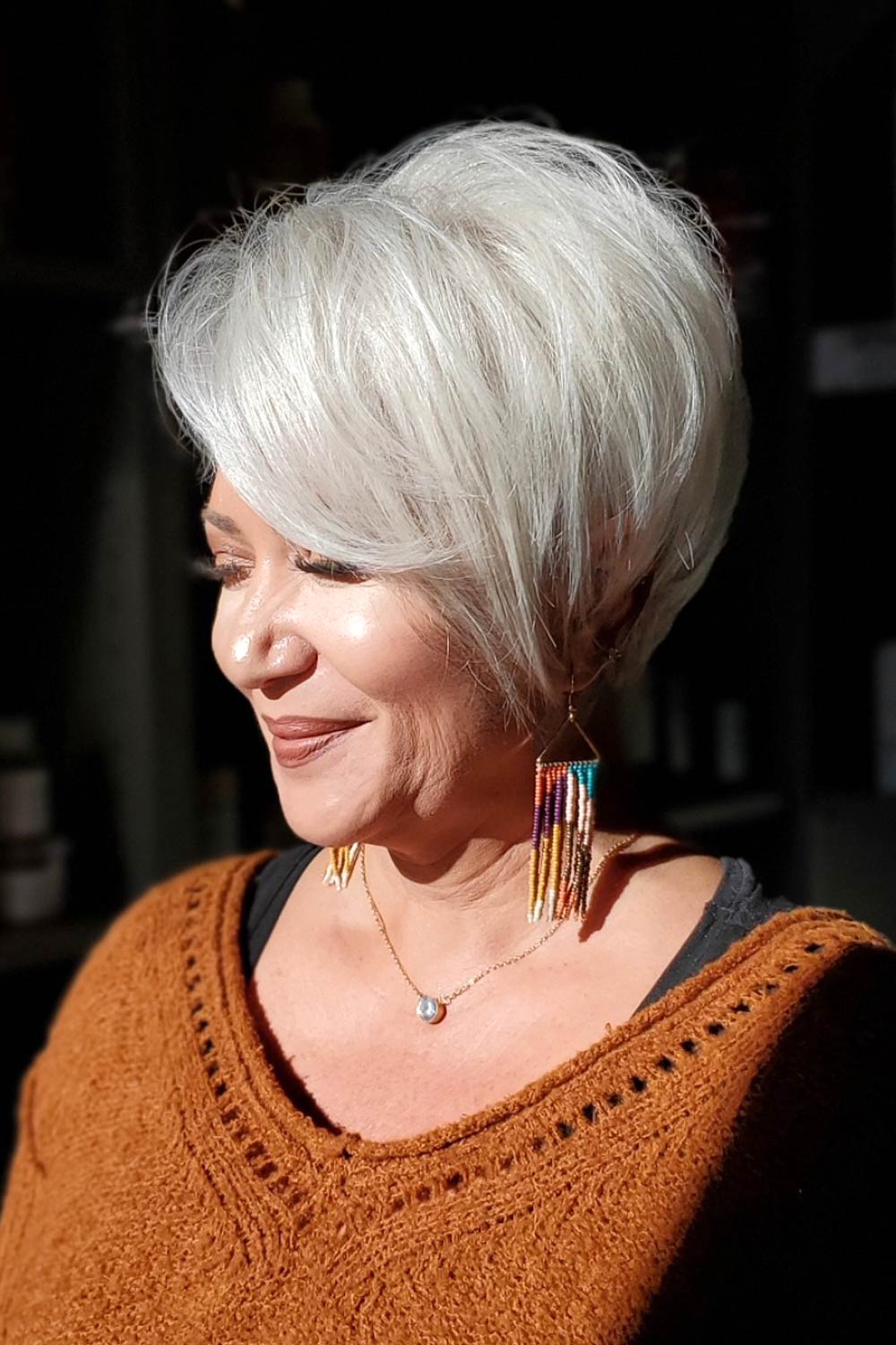 Woman With Short Layered Hair And Side Swept Bangs In Silver Tone