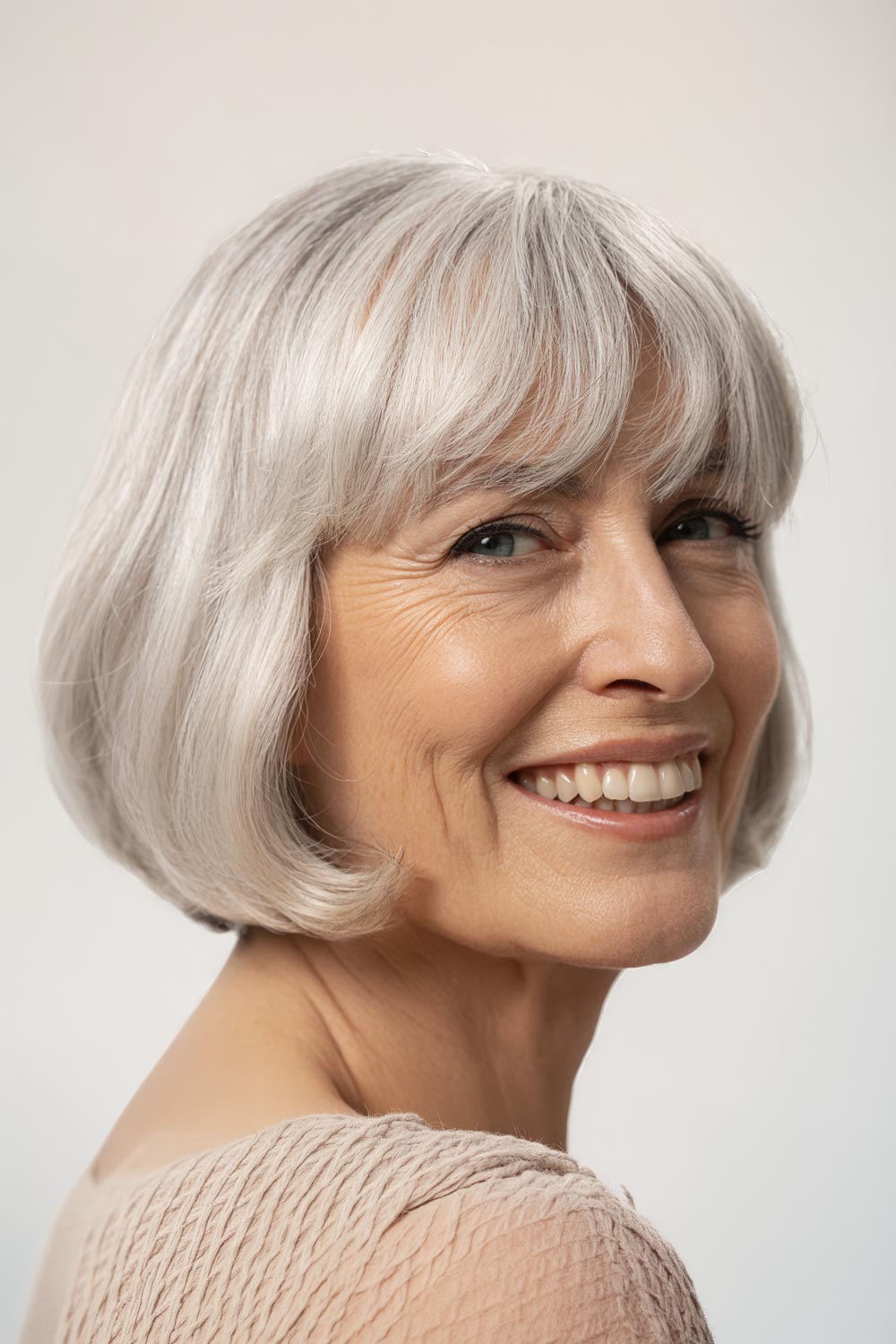 Silver Bob Haircut And Soft Full Bangs Smiling Side View